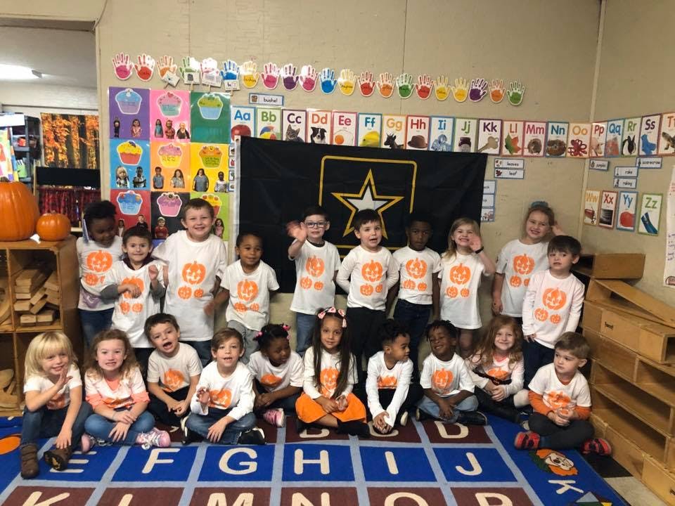 Group of children in a classroom wearing matching shirts
