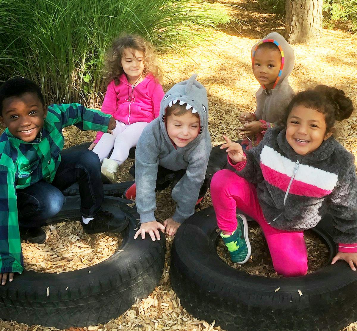 Group of children playing with tires outdoors