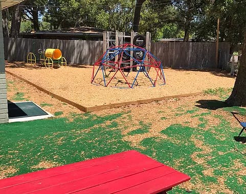 Playground with a geodesic dome climber and a yellow barrel
