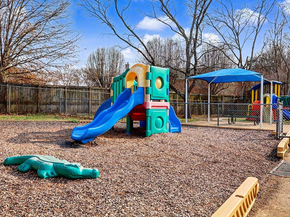 Colorful playground with a slide and a green alligator-shaped toy