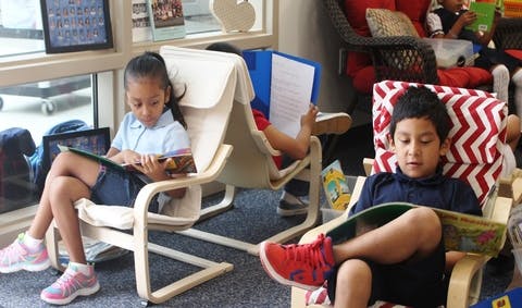 Children sitting in chairs and reading books