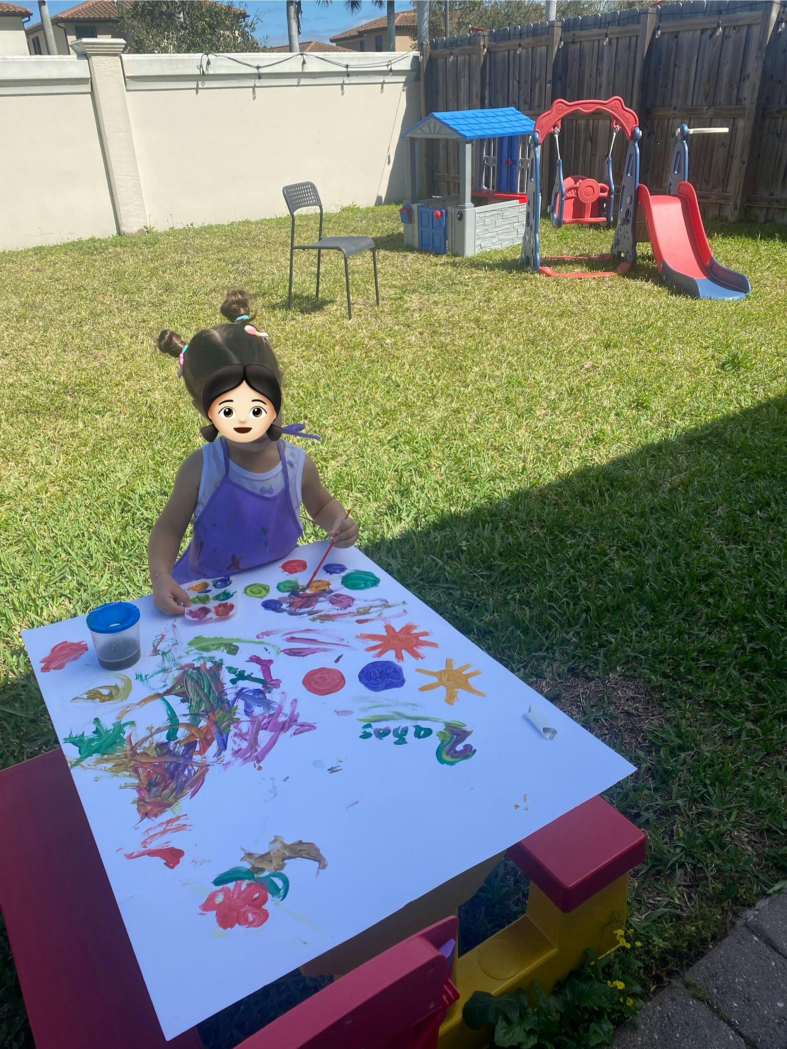 Child painting at a table outdoors