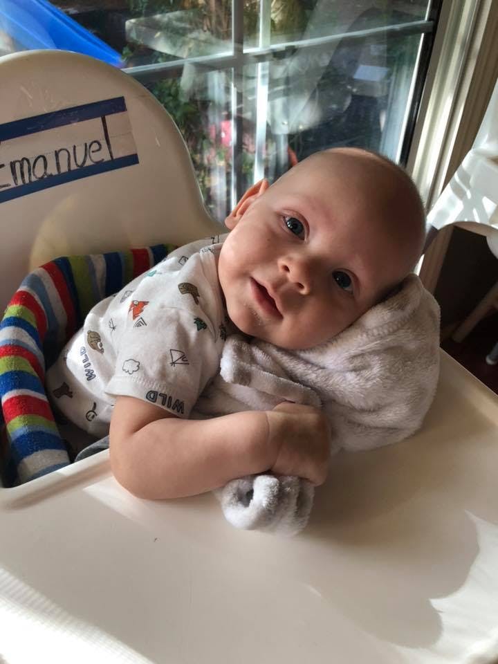 Child in a high chair with a pillow