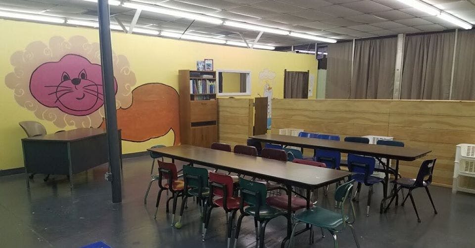 Classroom with tables and chairs, lion mural on wall
