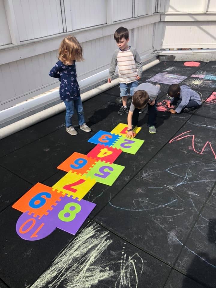 Children playing with number mats on a playground