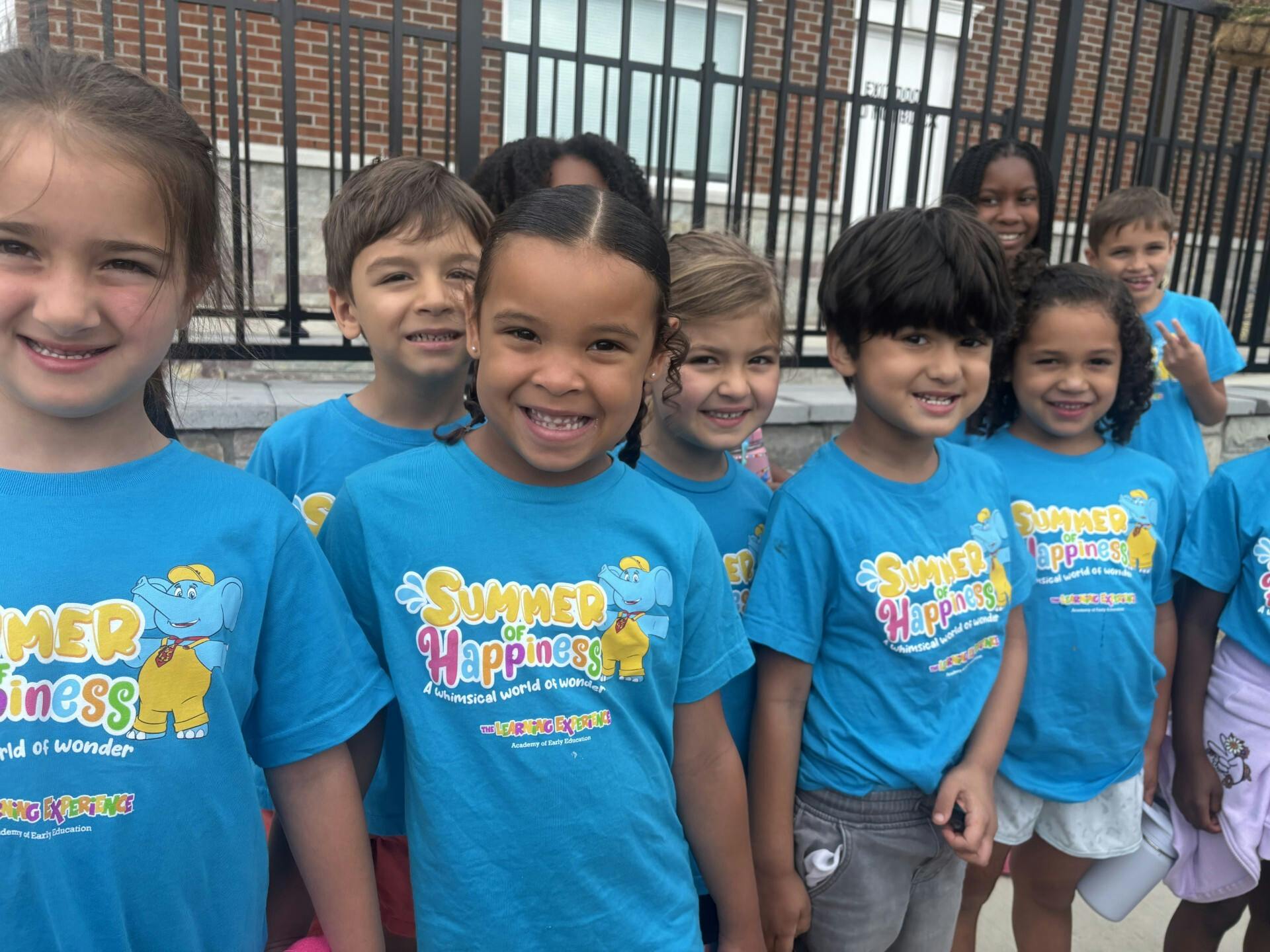 Group of children in blue t-shirts smiling