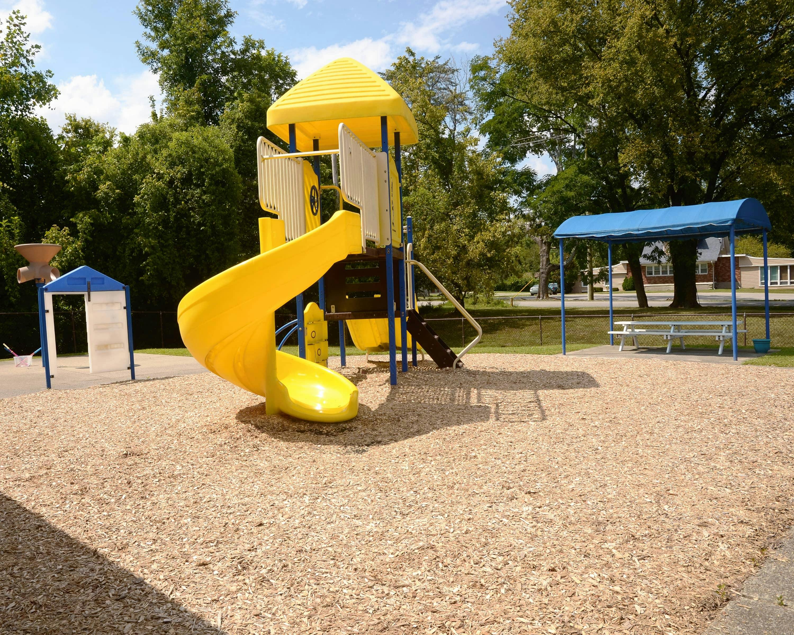 Yellow playground slide and structure on wood chips