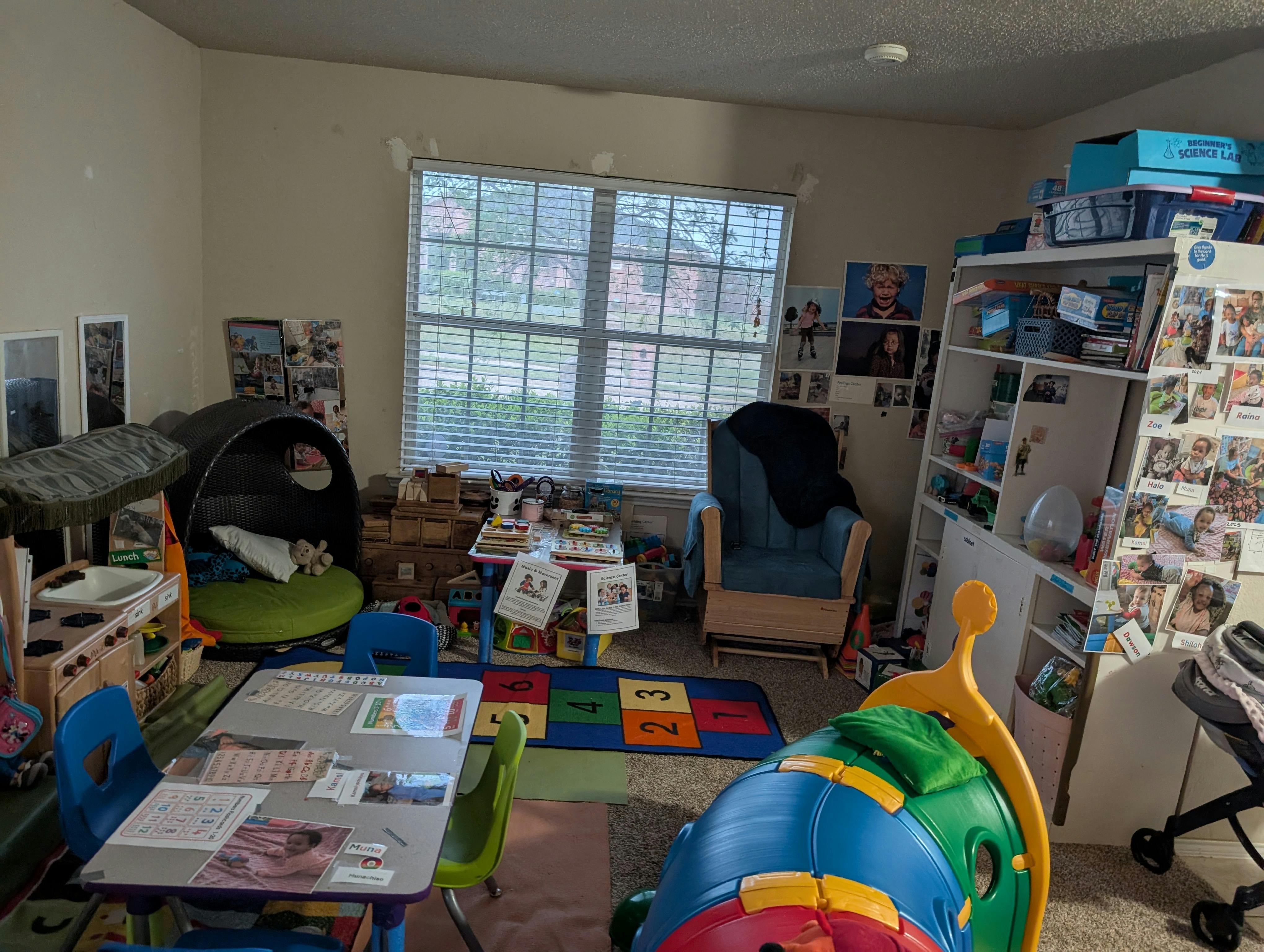 A playroom with children's furniture, shelves, and learning materials
