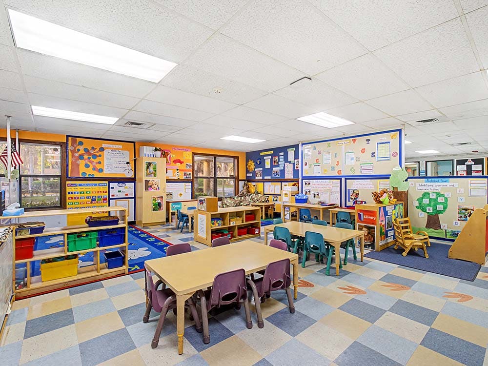 Empty classroom with small tables and chairs, and colorful decorations