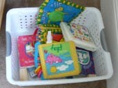 White laundry basket filled with children's toys and books
