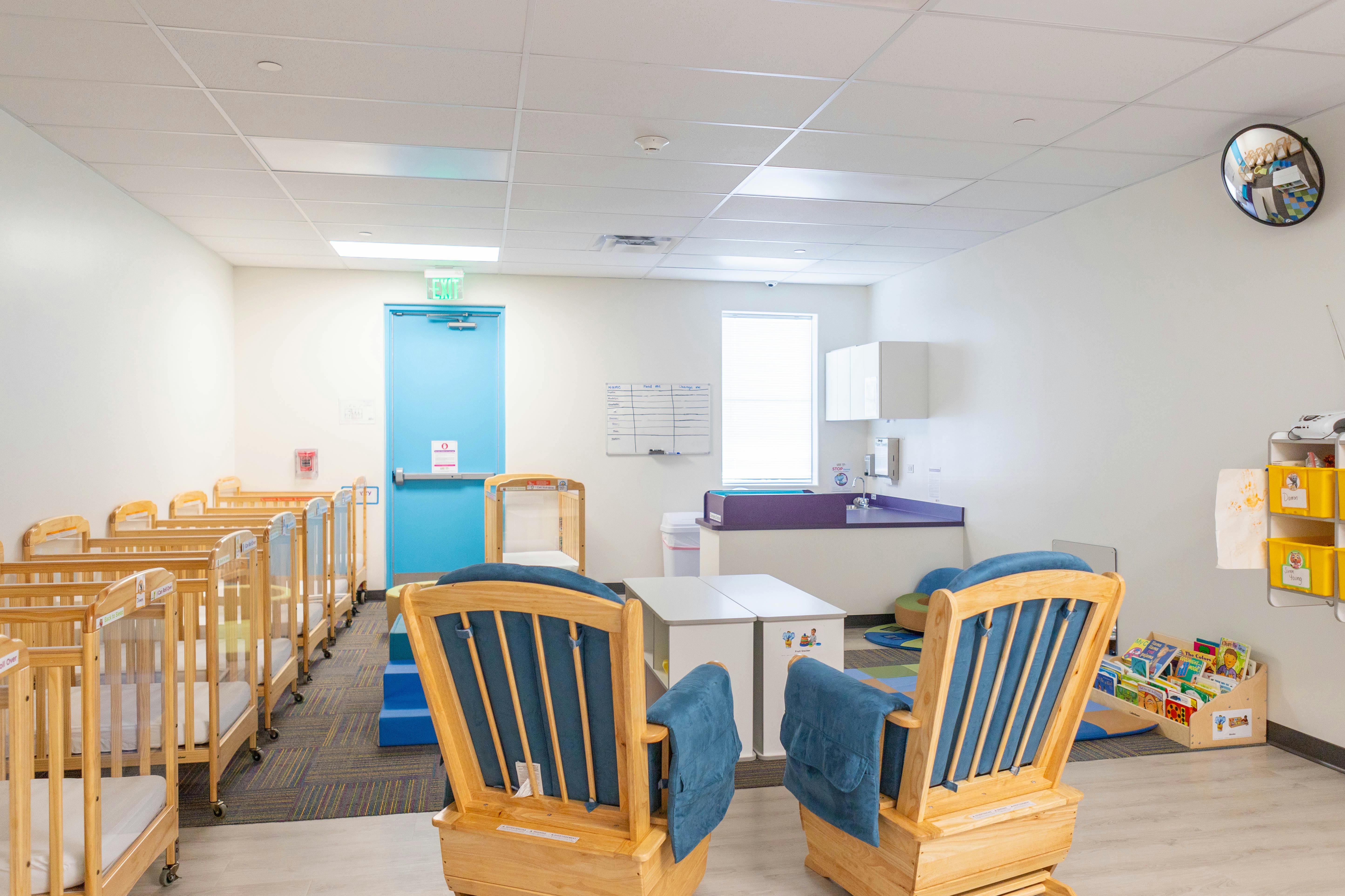 Nursery room with multiple cribs and two rocking chairs