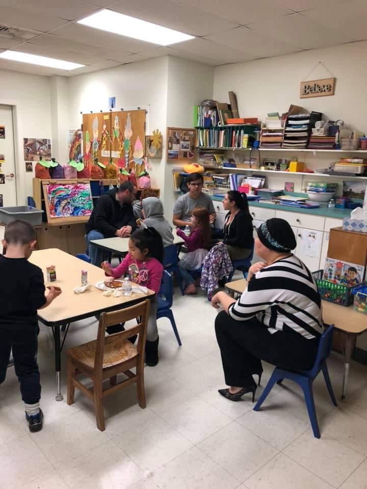 Adults and children gathered in a classroom