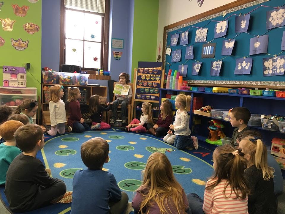 Adult reading to children in a classroom