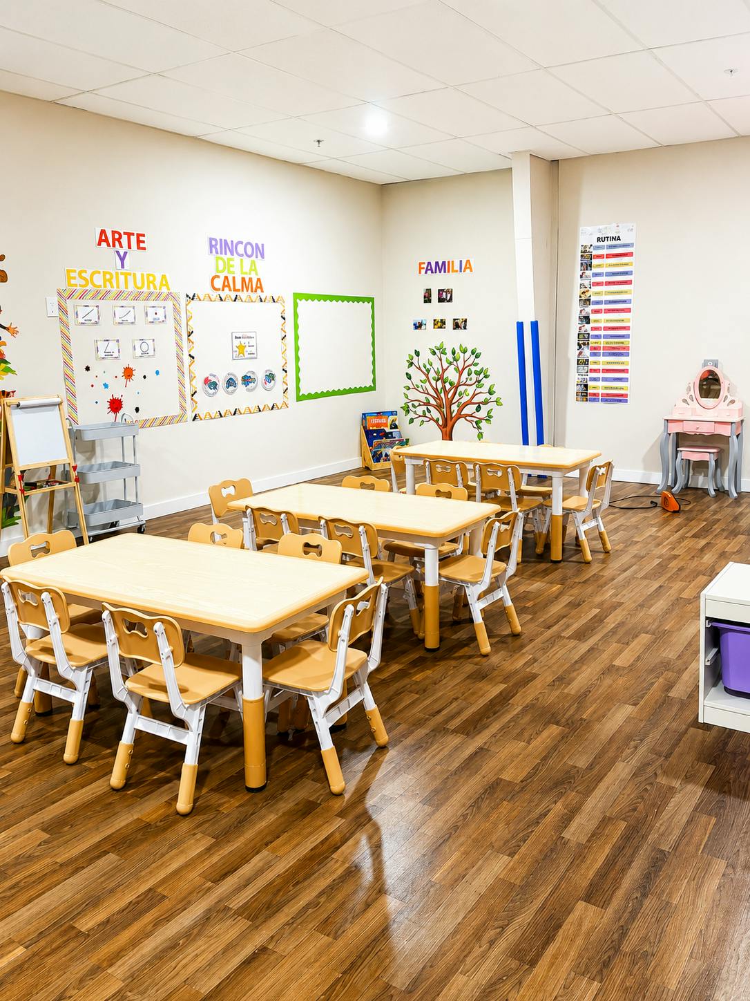Classroom with small tables and chairs, and Spanish words on the wall