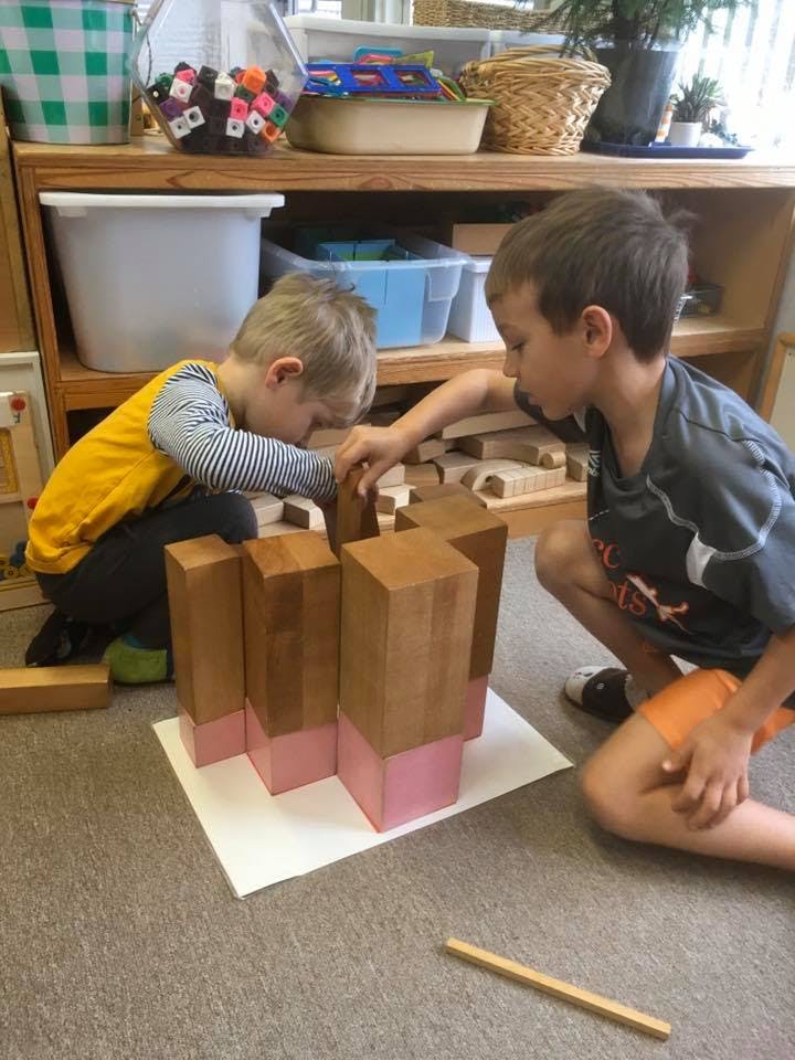 Two children building with blocks on the floor