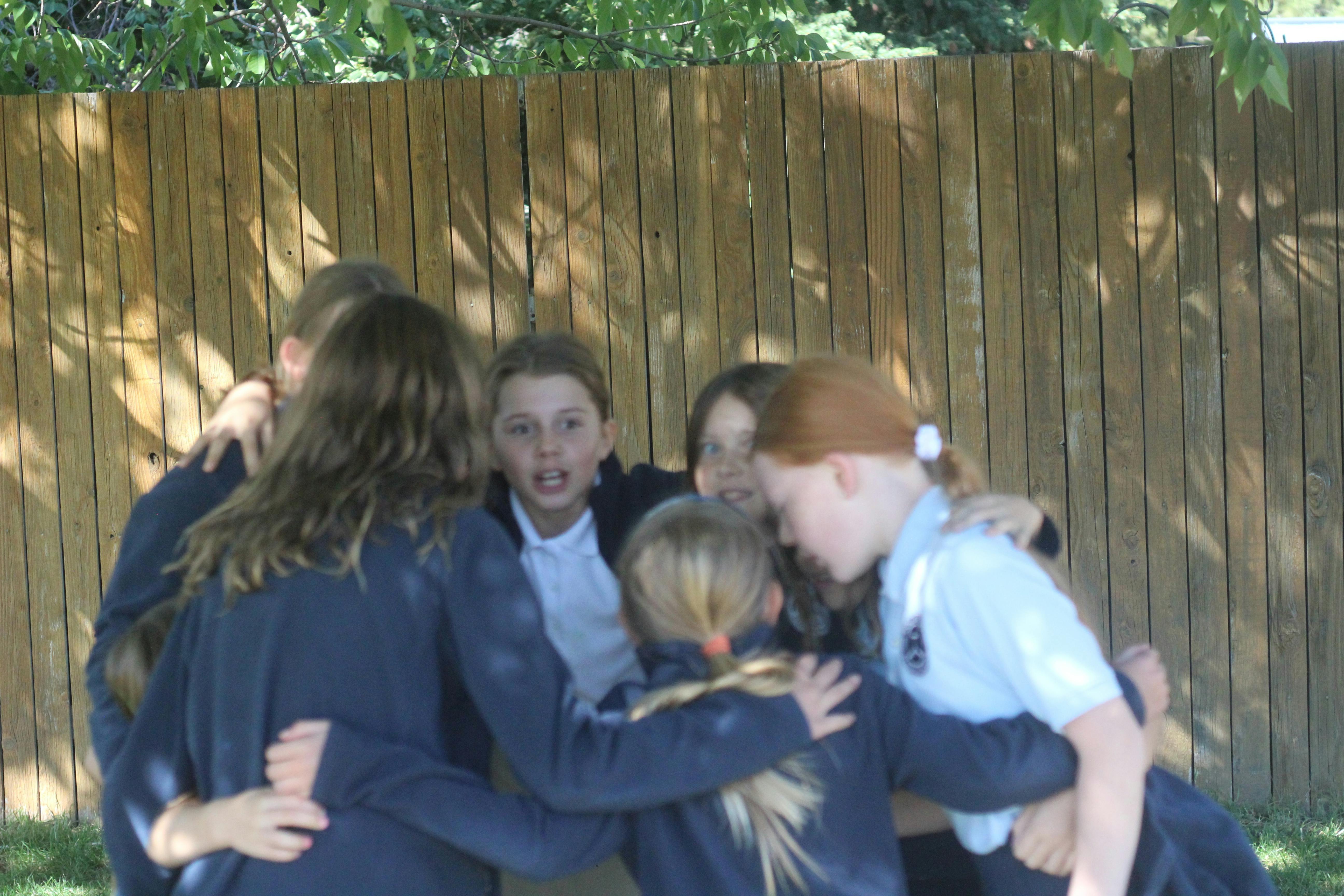 Group of children in uniform huddled together