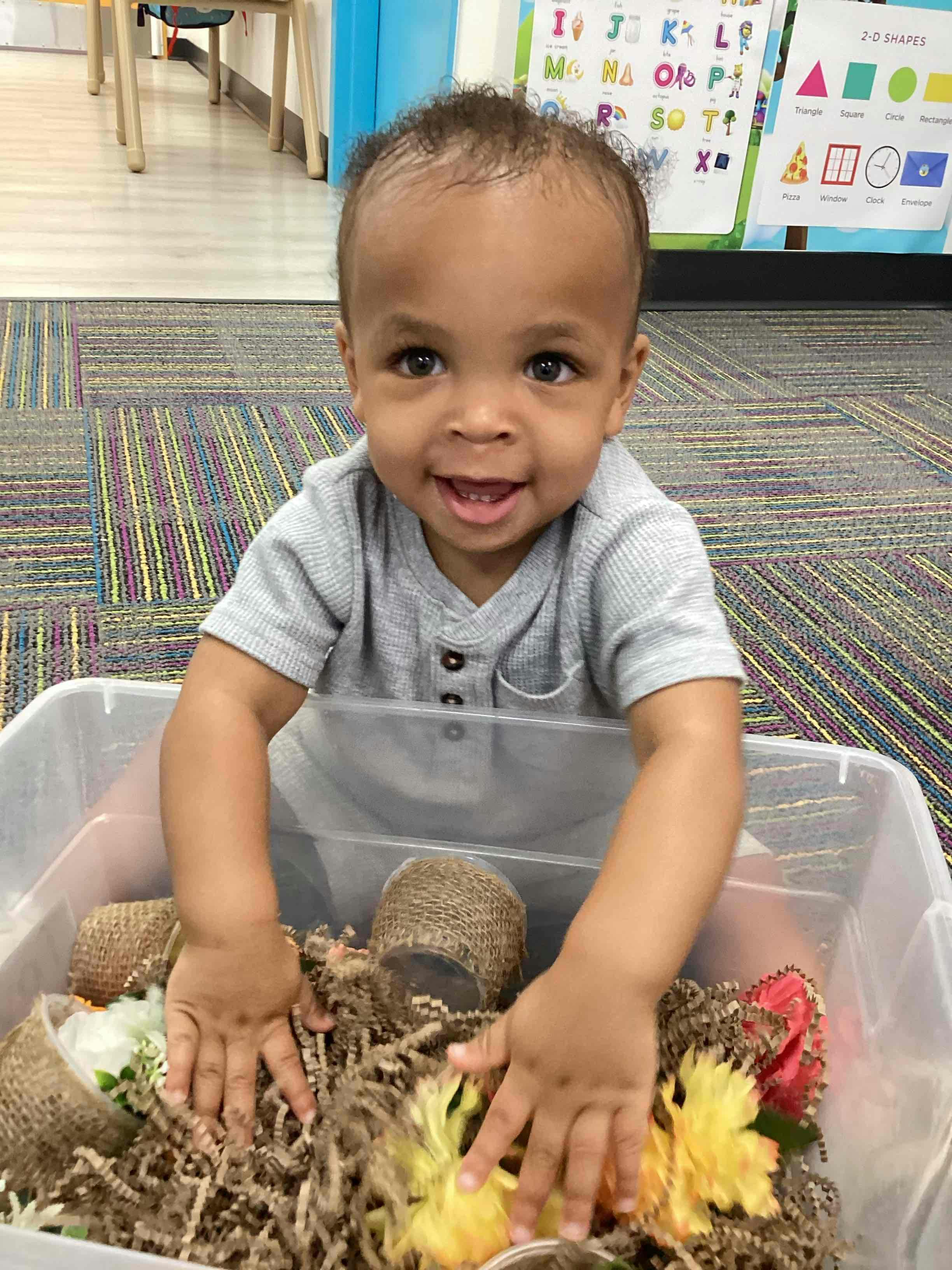 Child playing with sensory bin in a classroom