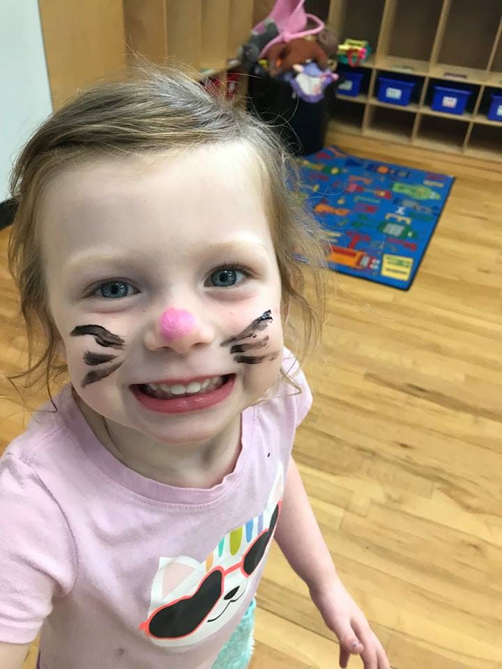 Child with face paint resembling a cat