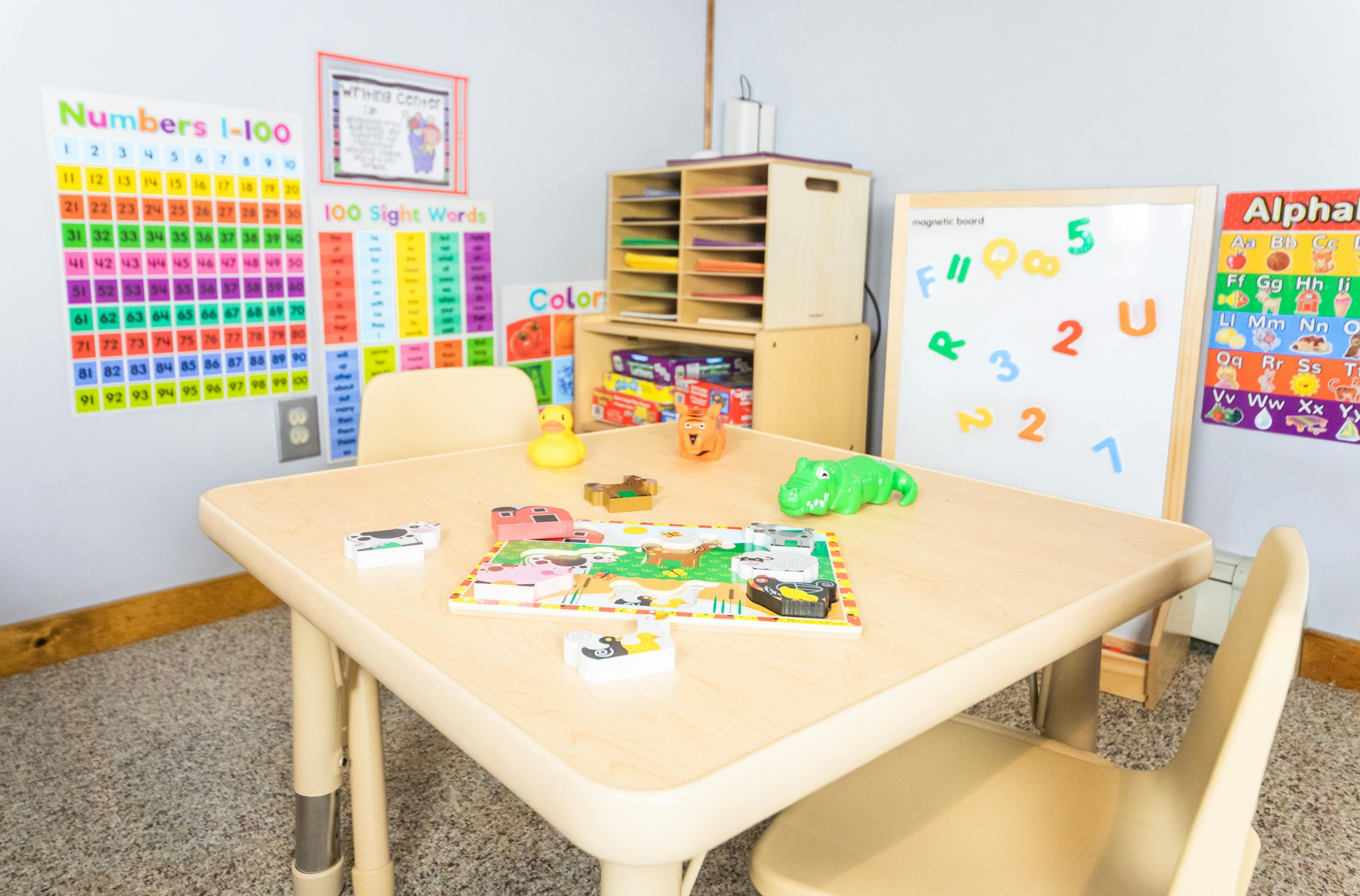 Child activity table with a puzzle and toys in a classroom setting