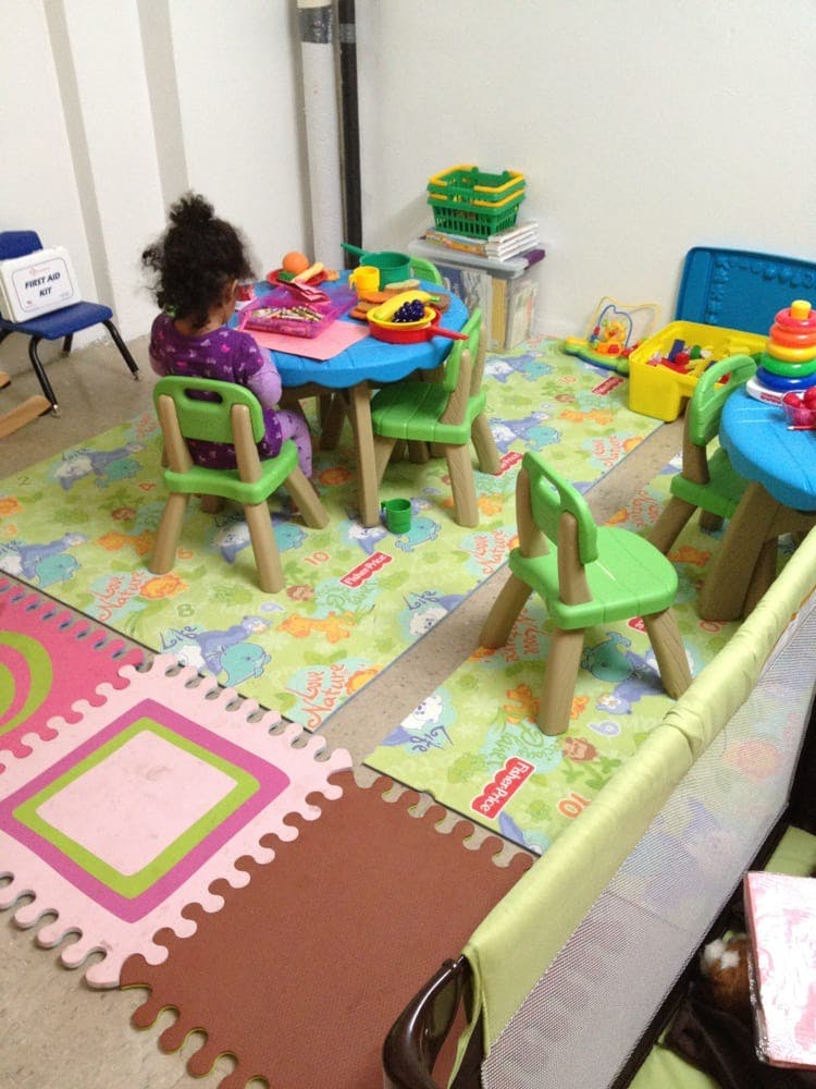 Child sitting at a small blue table with toys