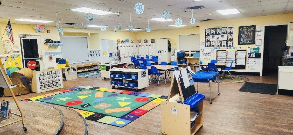 Colorful classroom with desks, chairs, and a playmat