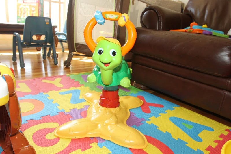 Turtle-shaped baby activity toy on an alphabet playmat