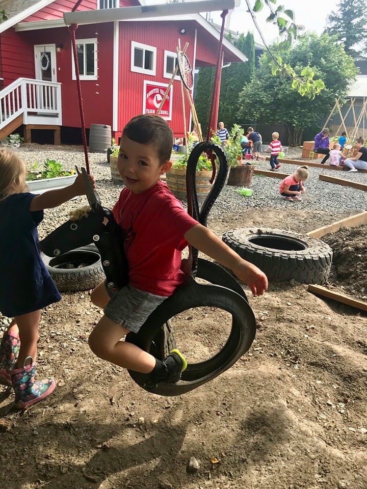 Child on a tire swing in a playground