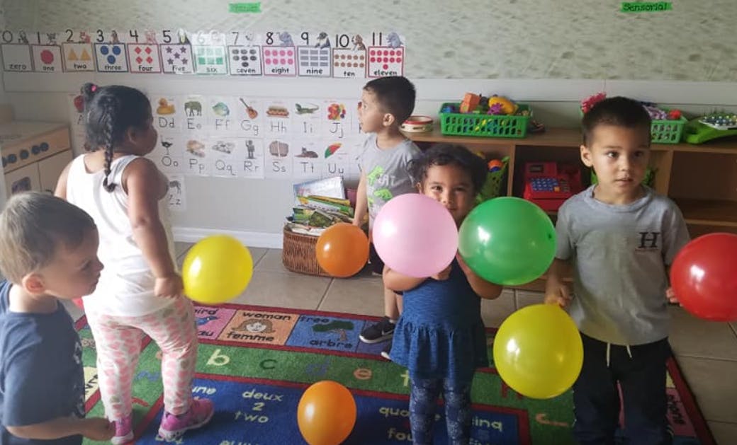 Children playing with balloons in a classroom