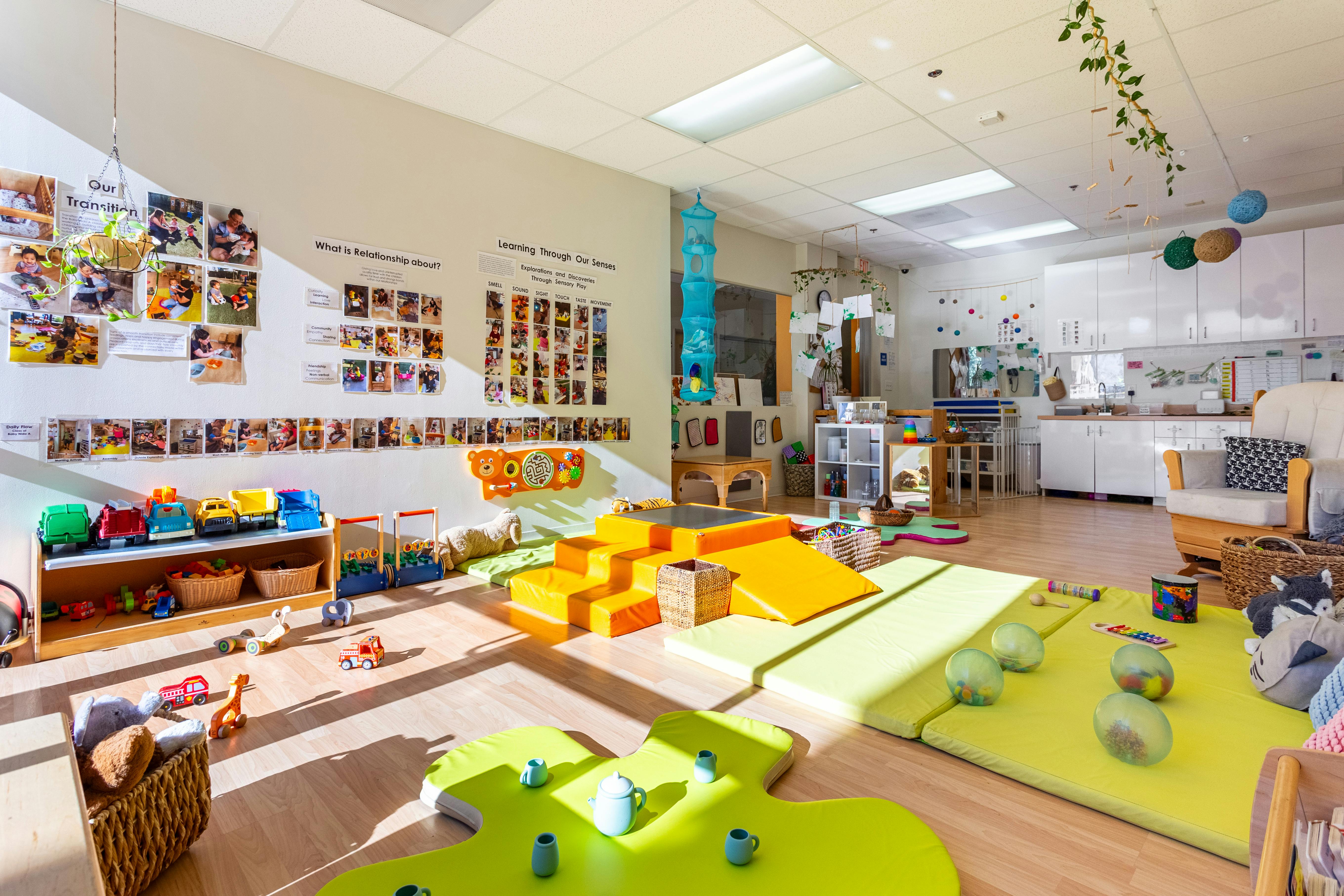 Playroom with soft play equipment, shelves of toys, and wall decorations