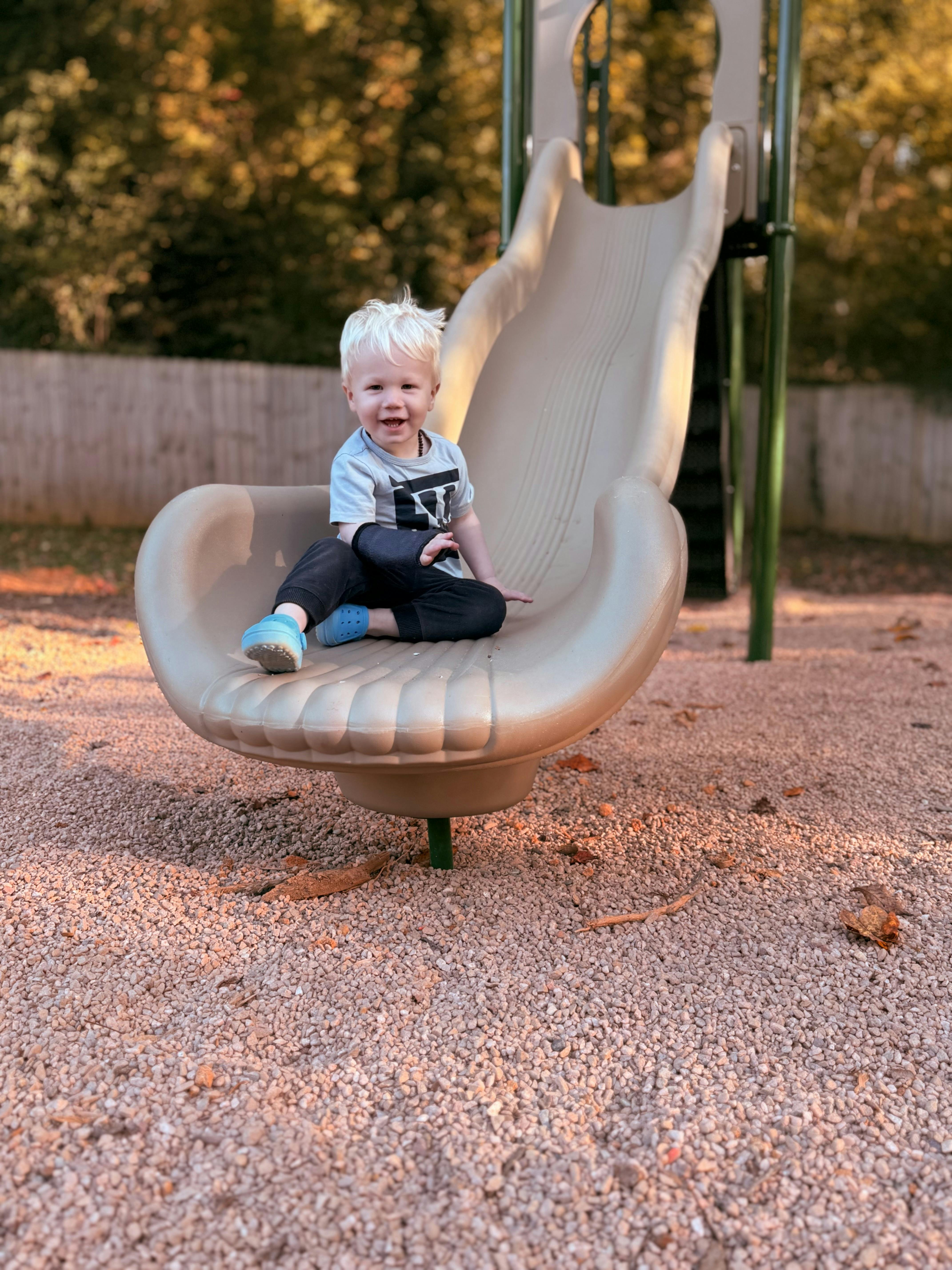 Child sitting on a slide on a playground