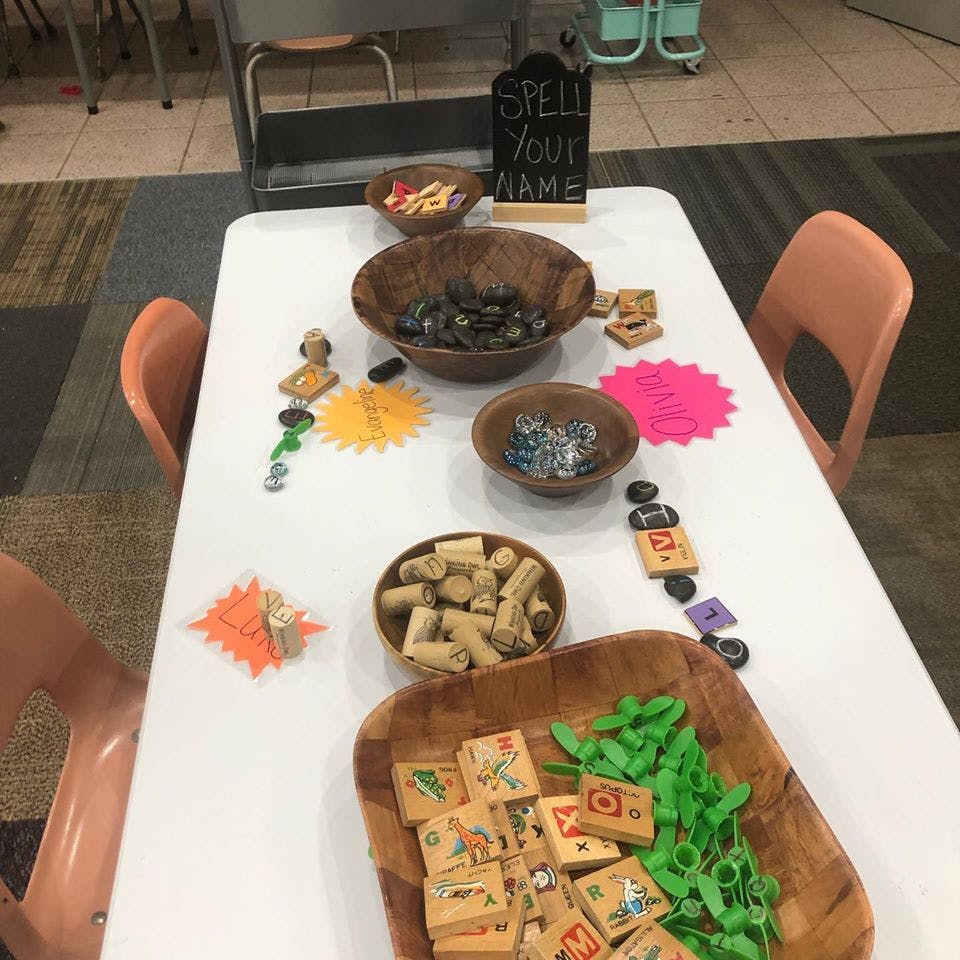 Table with bowls of craft supplies and a sign that says "Spell Your Name"