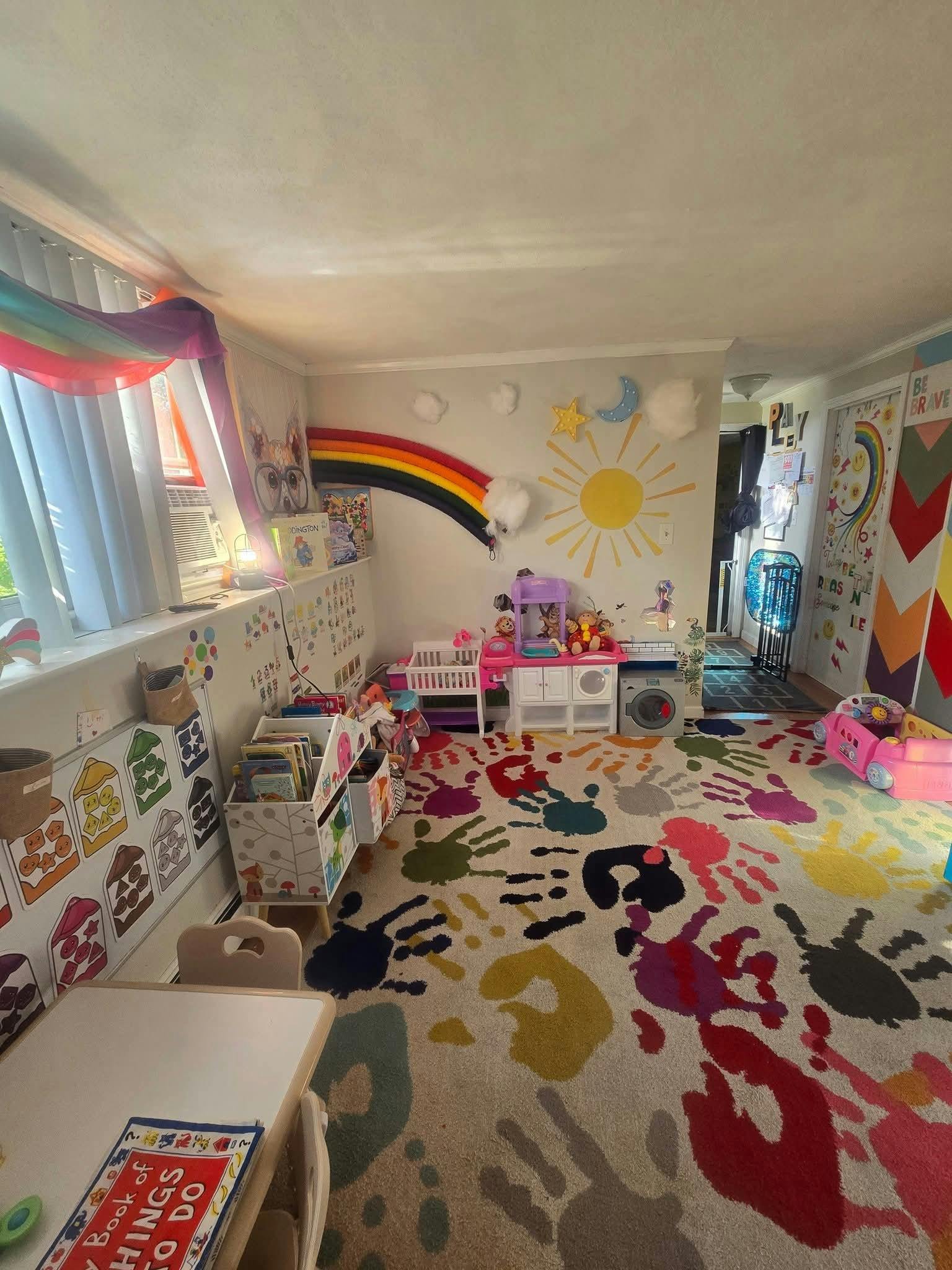Playroom with a colorful handprint rug and rainbow wall decor