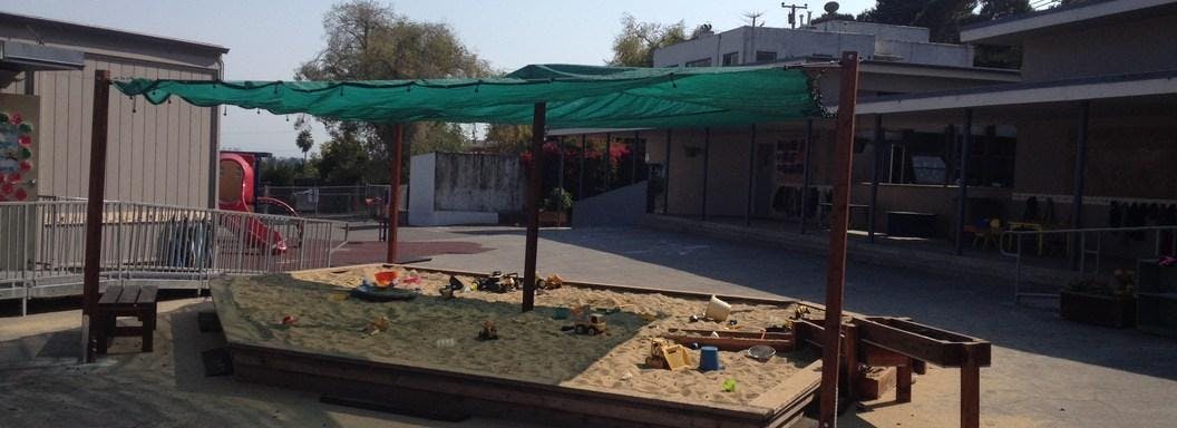 Sandbox with a green shade cover
