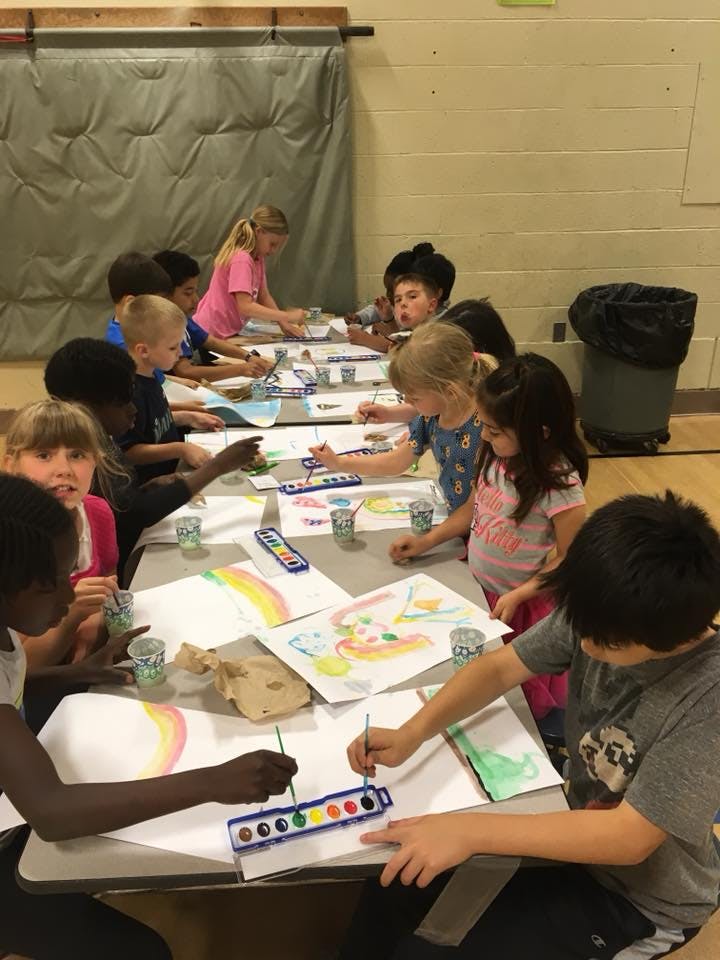 Children painting at a table in a classroom