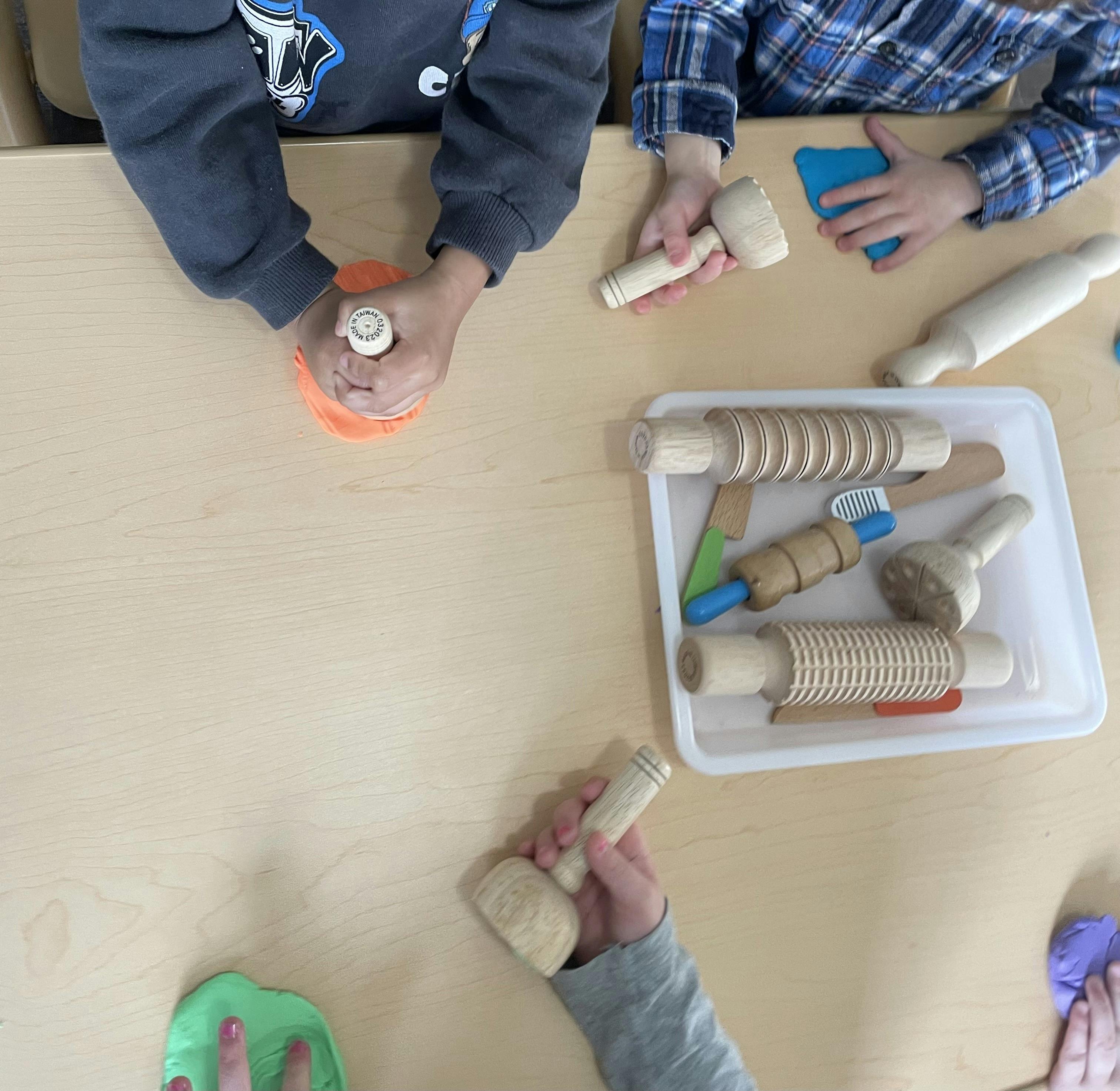 Children playing with modeling clay and wooden tools