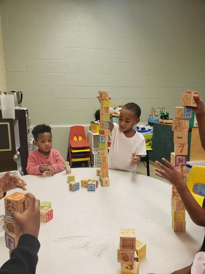 Children playing with building blocks at a table