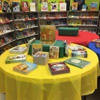 Books displayed on a table with a yellow tablecloth in a bookstore
