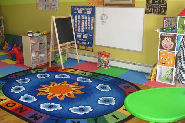 Playroom with alphabet rug, chalkboard, and whiteboard