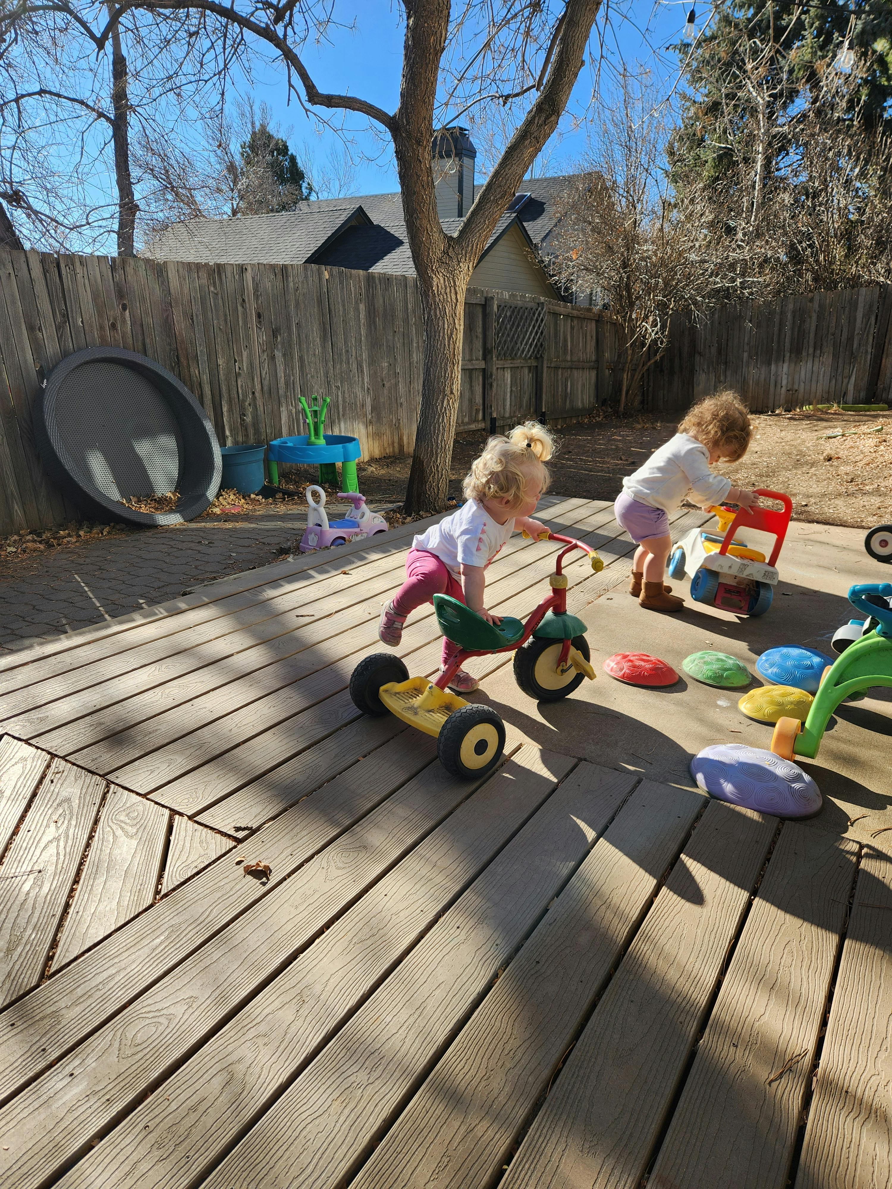 Two children playing with toys on a deck