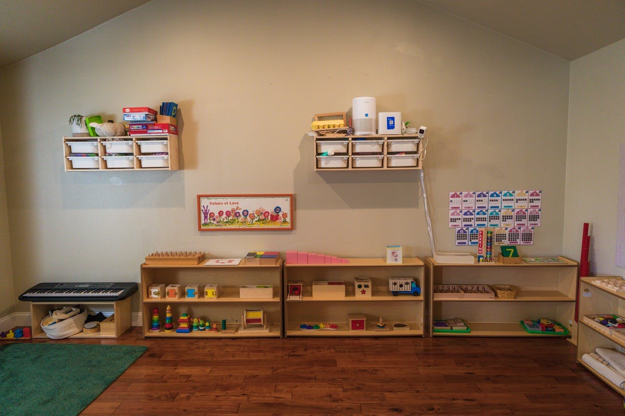 Wooden shelves with educational toys and learning materials in a play area