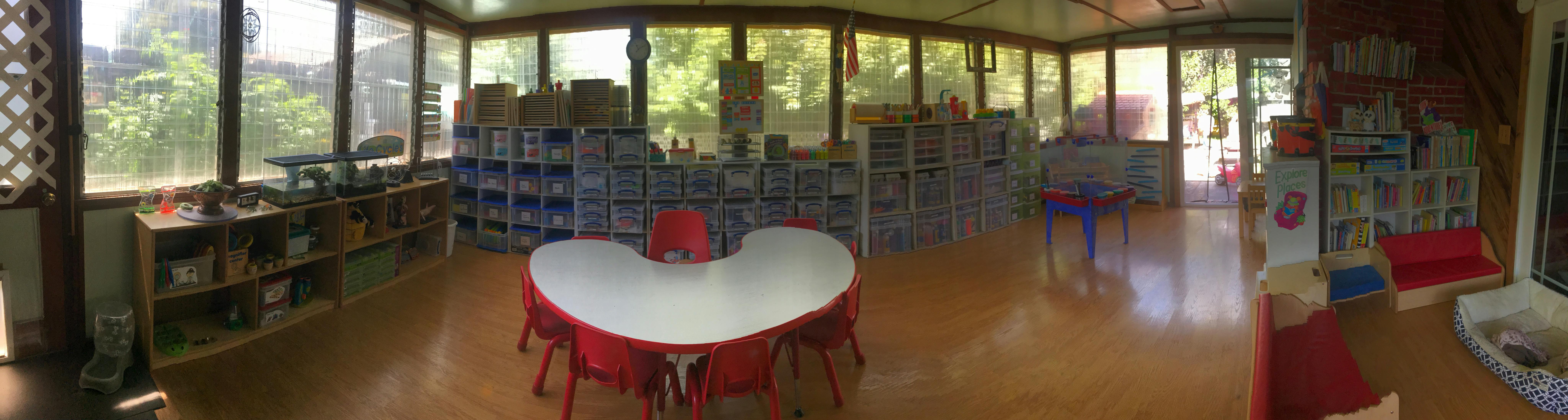 Classroom with a white kidney-shaped table and red chairs