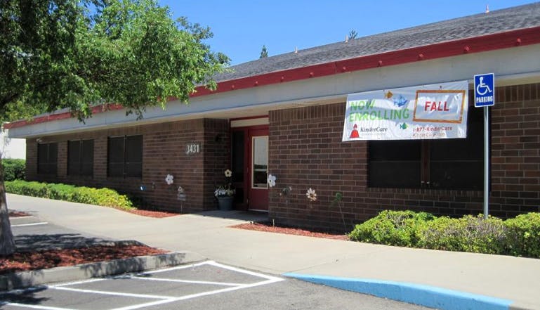 KinderCare building with "Now enrolling Fall" banner