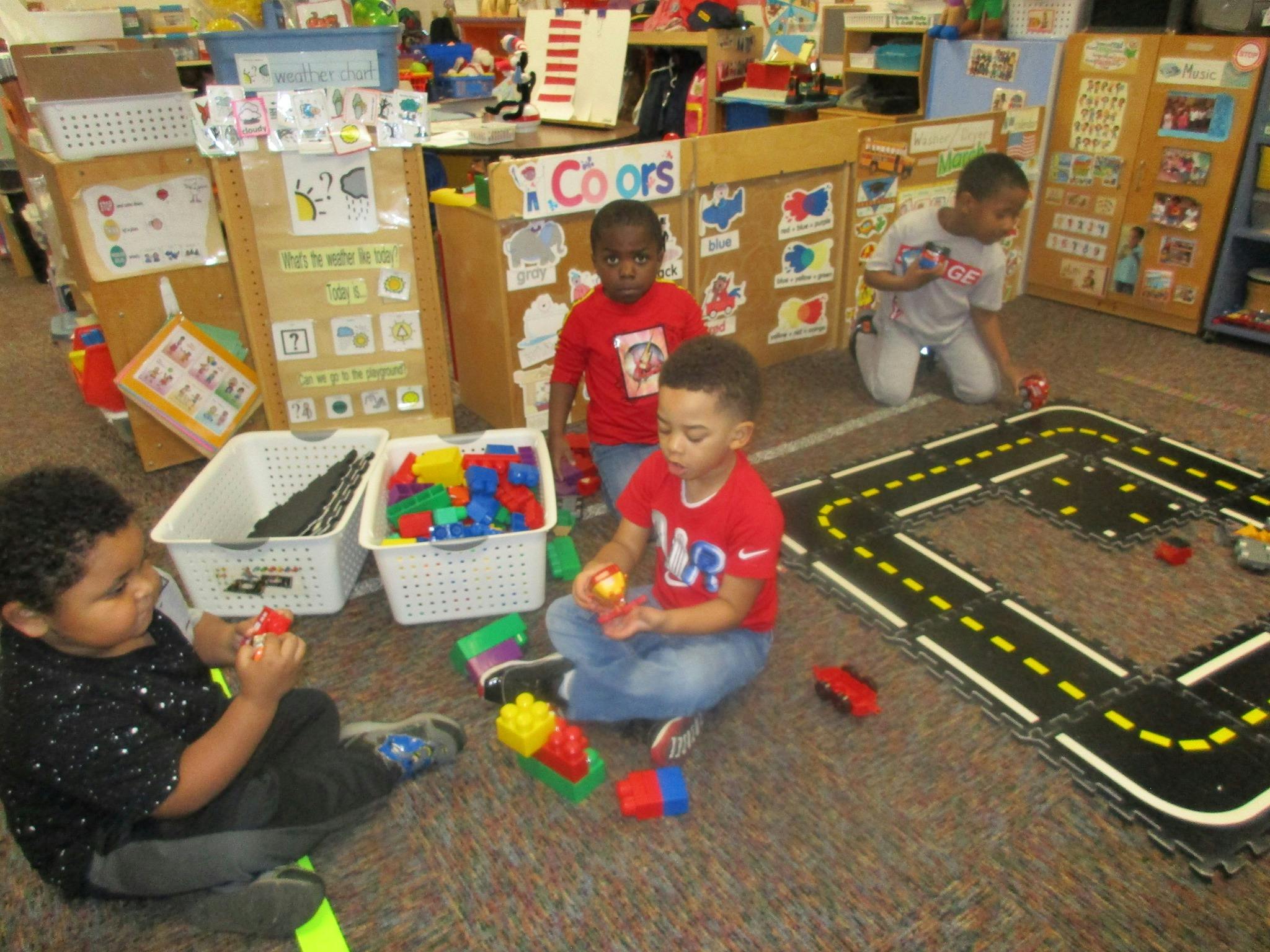 Four children playing with toys on the floor