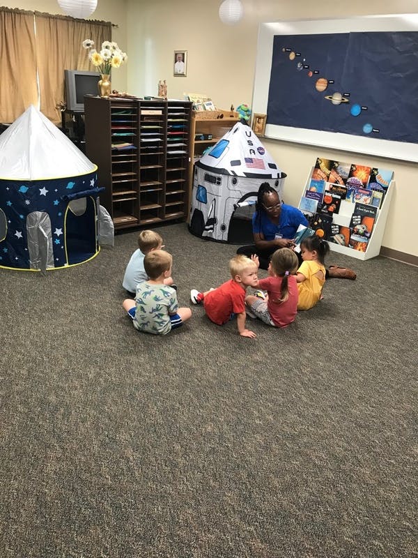 Adult reading to children in a classroom