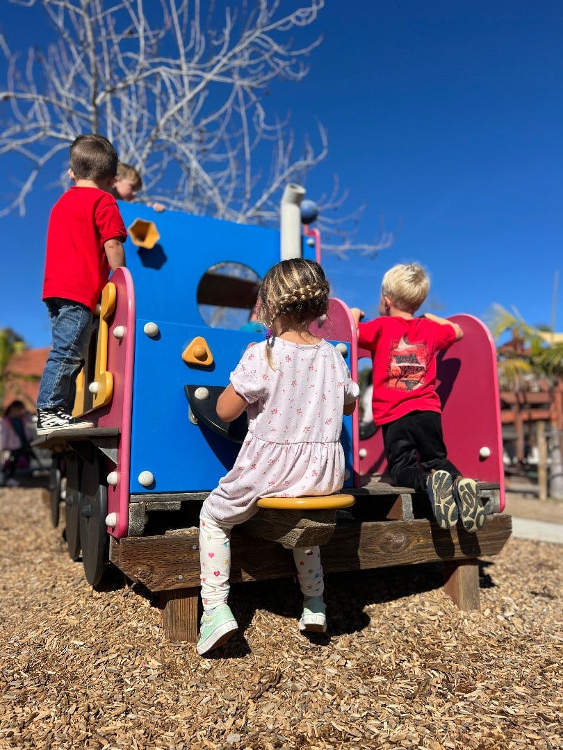 Children playing on a colorful playground structure