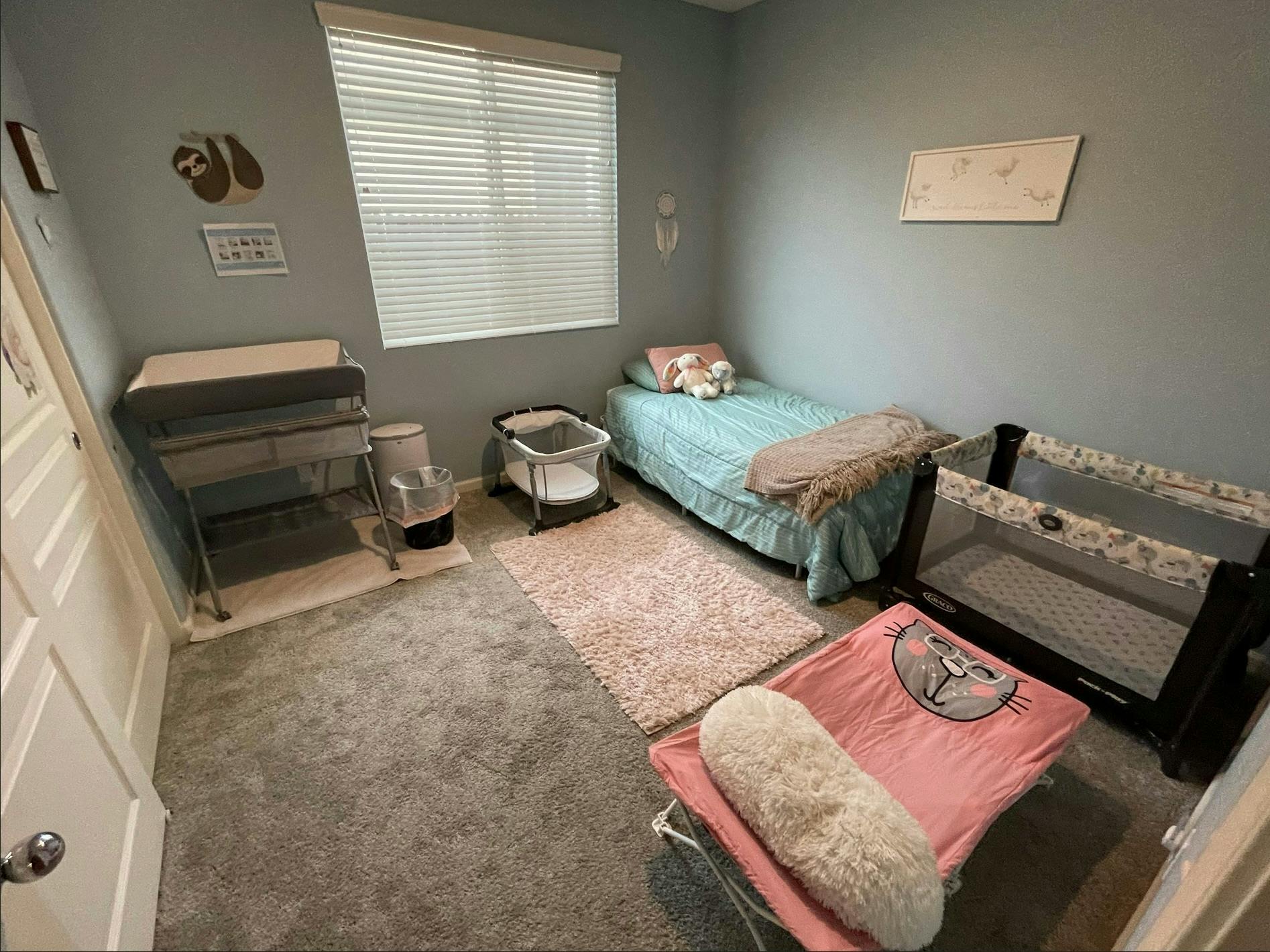 Bedroom with a bed, two cribs, and a changing table