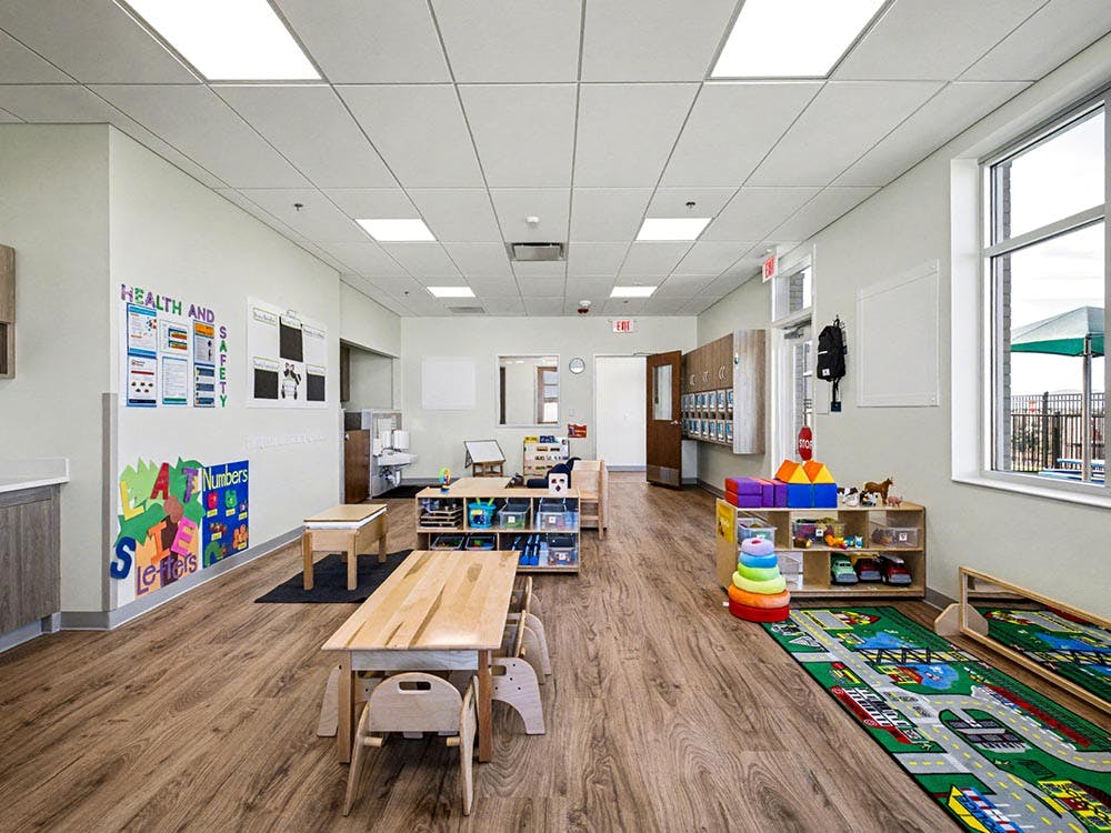 Empty colorful preschool classroom with small tables and chairs