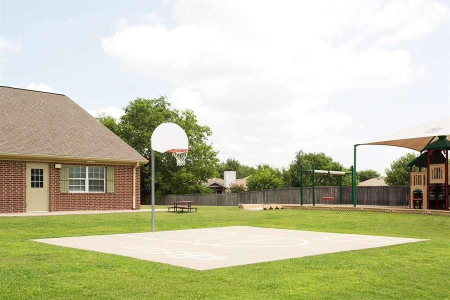 Outdoor basketball court with a hoop and a building in the background