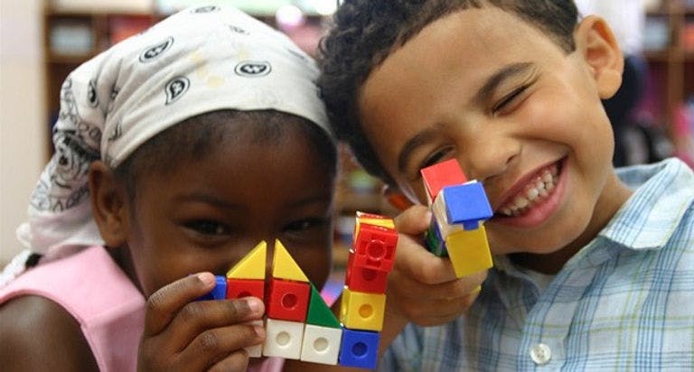 Two children playing with colorful building blocks