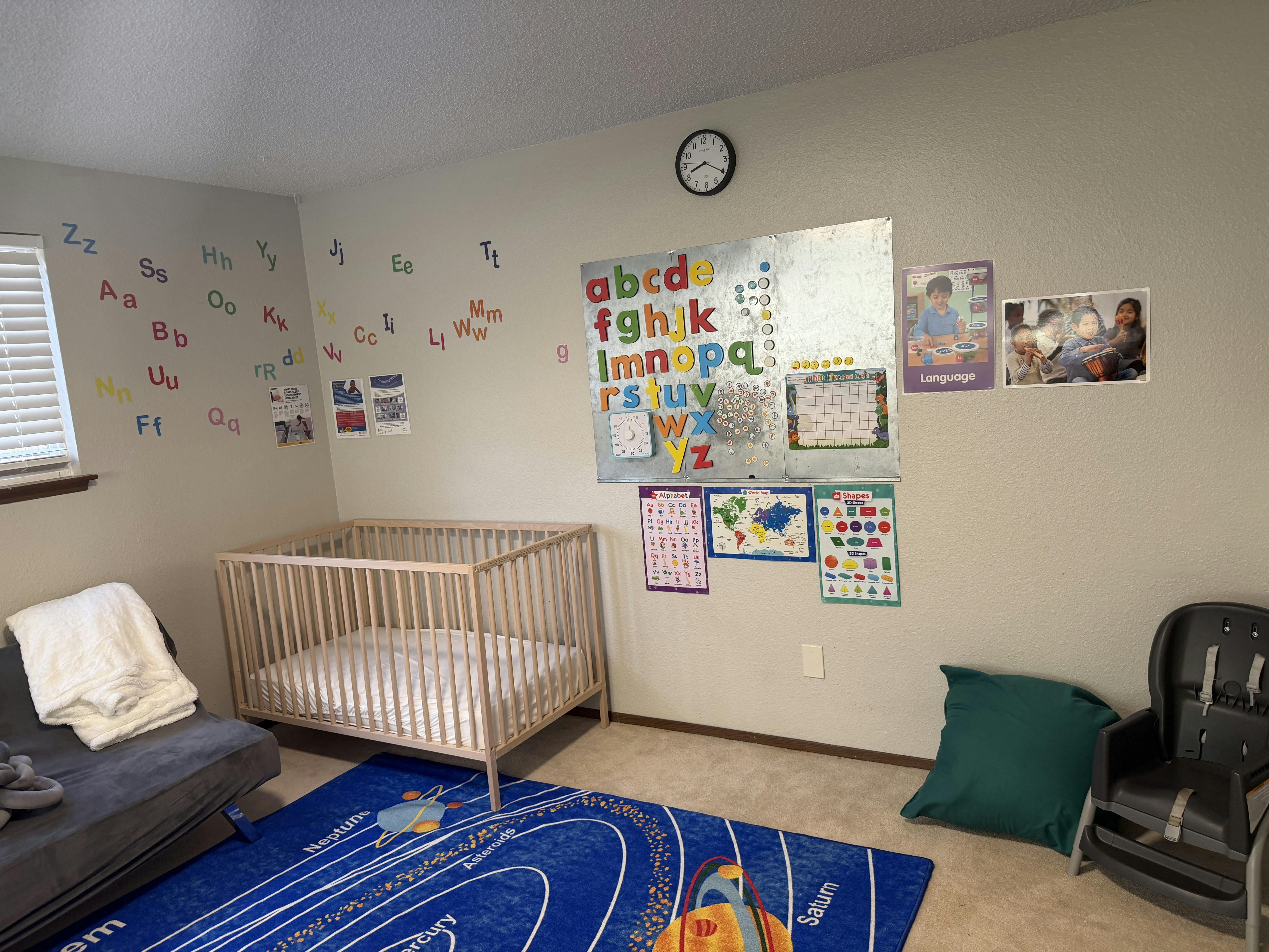 Crib in a child's learning room with educational posters and alphabet magnets